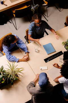 Creative professionals attending an informal meeting at a shared desk.