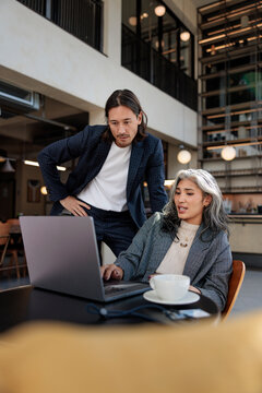Business colleagues collaborate on a laptop in a modern office
