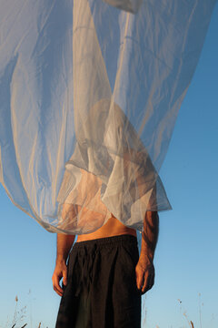 Man Standing in Field Portrait With Soft Fabric Against Blue Sky