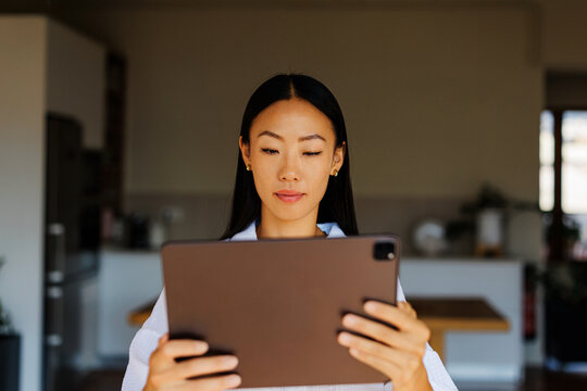 Woman using digital tablet concentrating on screen