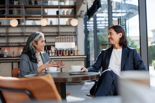 Two people enjoy coffee and conversation in a cafe