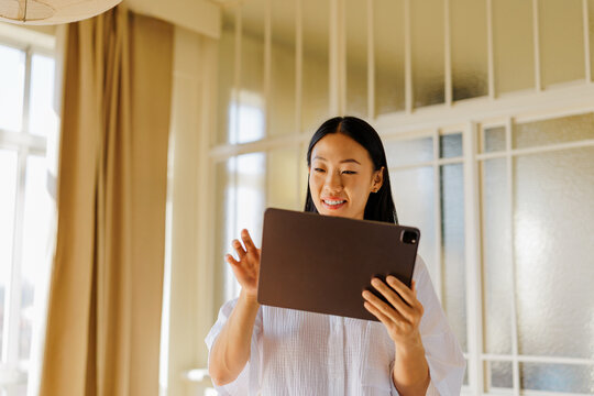 Woman laughing while working on the tablet