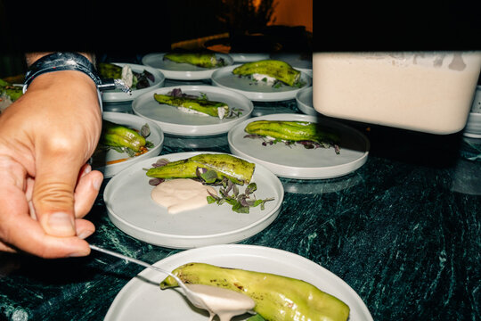 Chef Preparing Plates With Green Peppers and Sauce