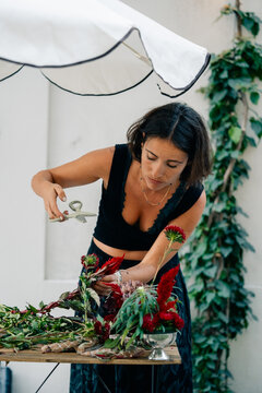 Woman Arranging Flowers in a Garden During Daylight
