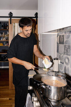 UGC Man adding butter while cooking dinner in home kitchen