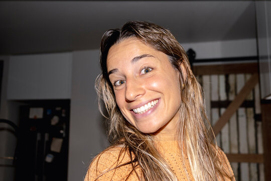 Smiling woman at home in candid flash lifestyle portrait