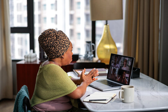 A woman participating in a virtual meeting on her laptop
