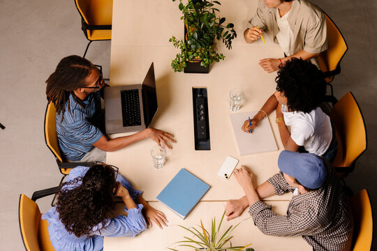Professionals working remotely from a shared coworking desk.