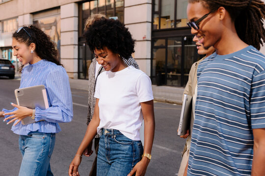 Professionals walking to work together, sharing ideas outdoors