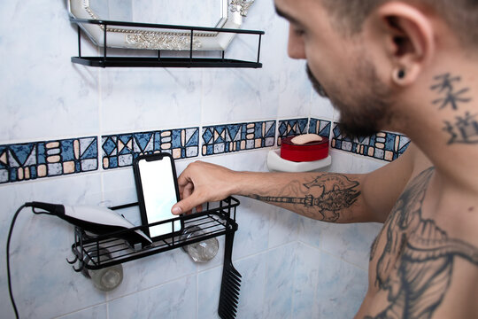 Man Using Phone While Standing in Bathroom