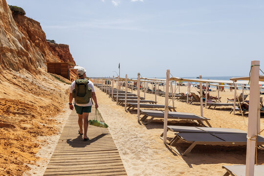 Traveler walking along beach boardwalk in Albufeira Algarve