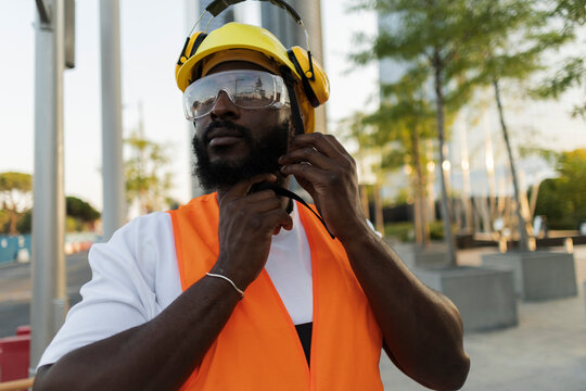 Black man adjusting hard hat for safety protection