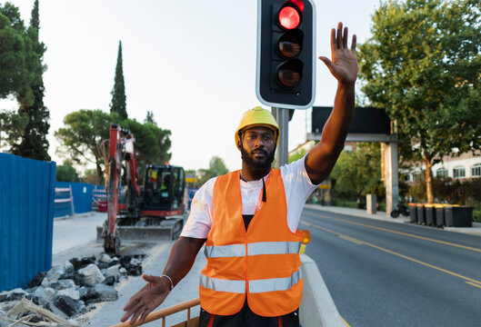 Construction worker directing traffic stopping on road