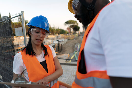 Construction workers discussing project plans on building site