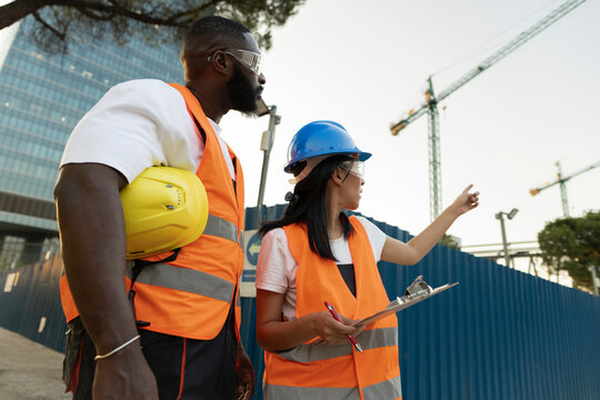 Diverse engineers reviewing construction site plans and progress