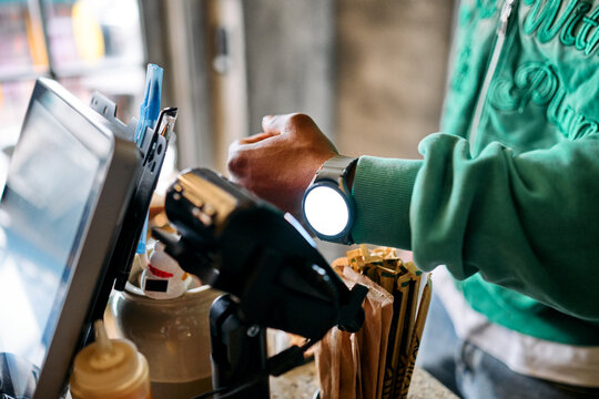 Customer Paying with Smartwatch via Contactless POS Terminal