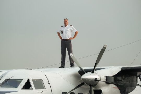Pilot Standing On Top Of Propeller Aircraft