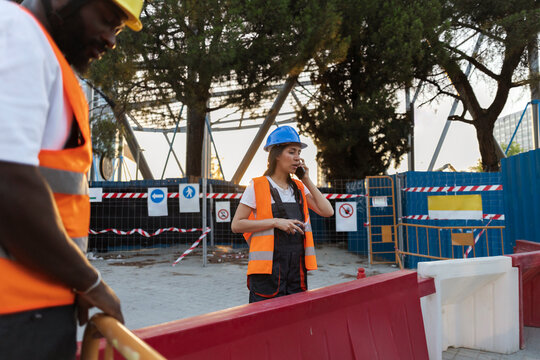 Female construction worker talking on mobile phone at