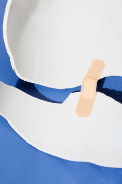 Conceptual image of healing: broken surface fixed with plaster bandaid