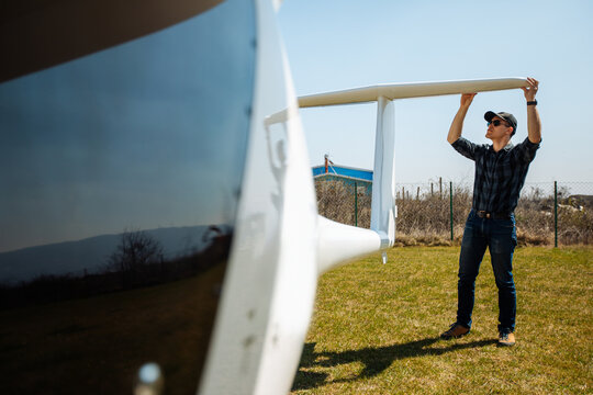 Pilot Inspecting Glider Wing Before Flight On Airfield