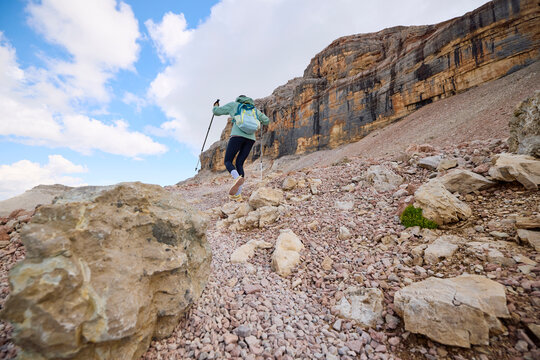 Woman walks through rocky terrain in the Dolomites.