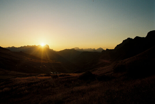 Sun sets over mountain peaks in the Dolomites