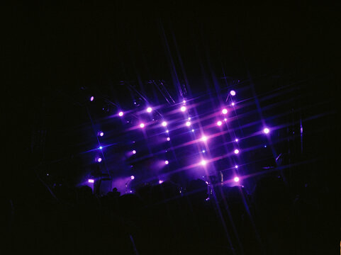 Purple lights illuminate the concert venue at night