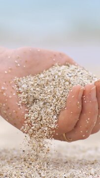 Sand falling from hand in slow motion on a beach. Vacation and travel concept. Shot on super slow motion camera 1000 fps.