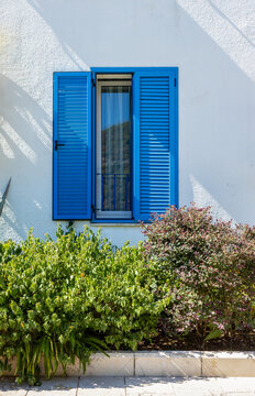 A window with blue shutters in the southern Mediterranean.
