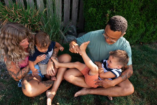Playful family moment outdoors with parents tickling children