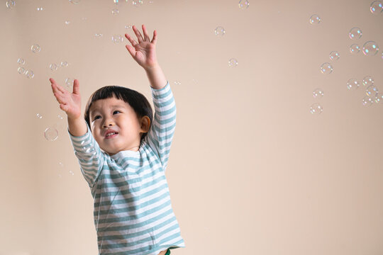 Joyful Child Playing With Bubbles