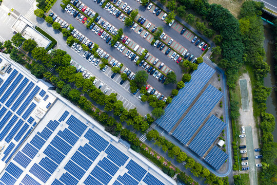 tree-lined parking lot beside solar rooftop factory