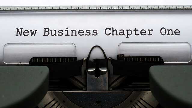 Vintage typewriter printing the words New Business Chapter One on white paper