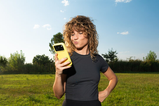 Woman enjoying leisure time under blue sky while checking phone