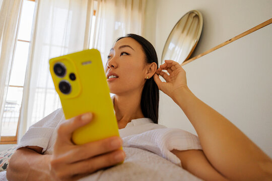 Woman relaxing at home using digital device