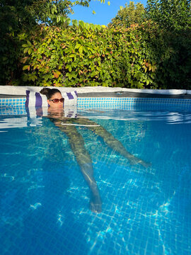 Girl relaxing and enjoying summer and warm sunshine in a pool.