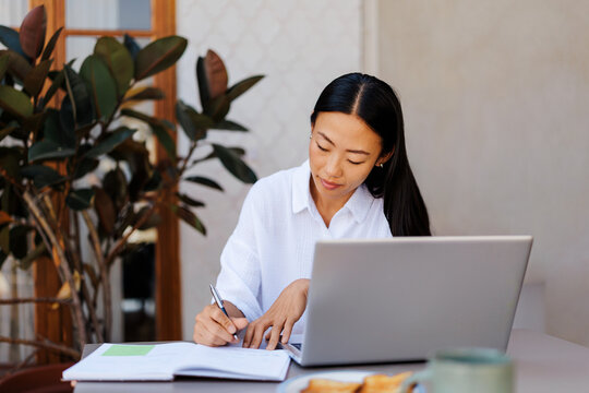 Woman working studying online with laptop and notebook