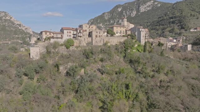 Aerial view of the historic stone village of Papigno perched on a hillside near the Marmore Falls, surrounded by lush vegetation and rolling hills in Terni, Umbria, Italy.