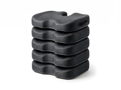 Stack of black ergonomic orthopedic seat cushions isolated on white background