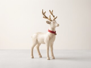 Ceramic reindeer Christmas figurine with gold antlers on a neutral background © kavindu