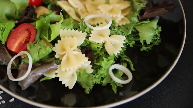 Pasta Salad tomato, green lettuce, farfalle pasta serving size vegetarian and vegan food natural ingredients healthy eating, wholesome tasty dish, snack fresh, gourmet, rustic food background on the t