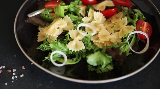 Pasta Salad tomato, green lettuce, farfalle pasta serving size vegetarian and vegan food natural ingredients healthy eating, wholesome tasty dish, snack fresh, gourmet, rustic food background on the t