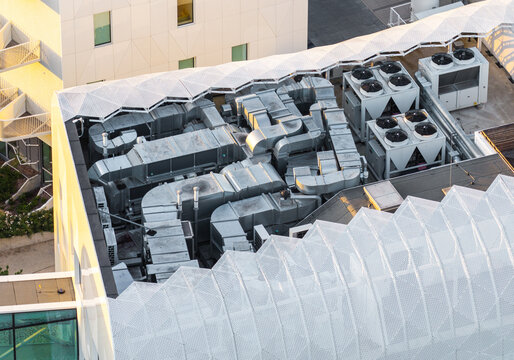 Aerial view of the modern medical resort rooftop with industrial HVAC ventilation ducts and cooling units integrated with white architectural mesh in Sopot, Pomeranian Voivodeshi, Poland.