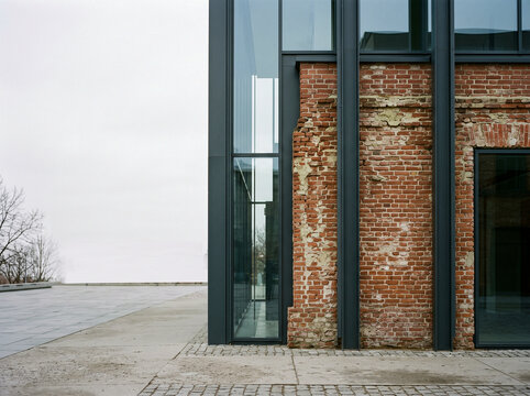 Modern architectural renovation combining historical red brick facade with contemporary steel beams and glass windows