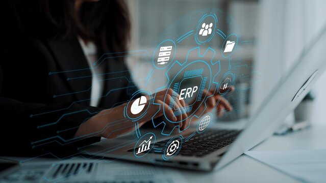 Business Professional Using Laptop with ERP Software Interface and Data Visualization in Modern Office Environment. Entropy.