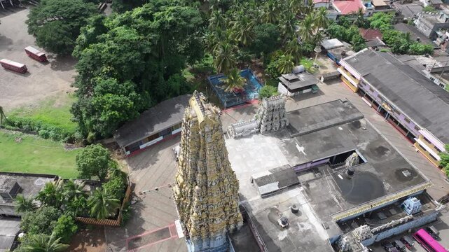 Aerial view of the ornate gopuram of Sri Muthumariamman Temple surrounded by lush trees and urban buildings in Kandy, Central Province, Sri Lanka.