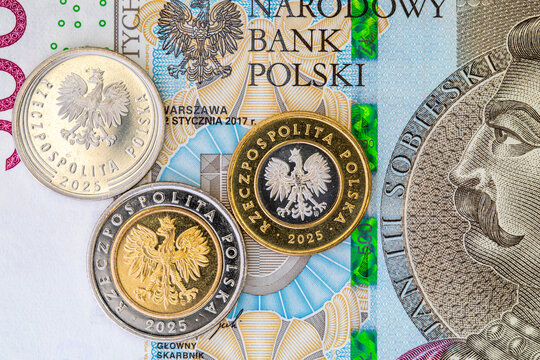 Polish zloty coins with coat of arms eagle lying on top of 500 zloty banknote. Concept of Polish national currency PLN. European finance.