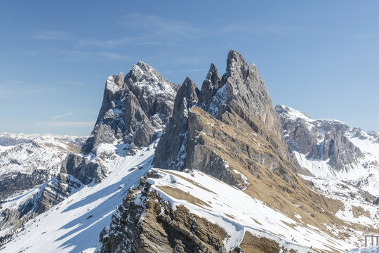 Snow covers the mountain peaks of Seceda in the Dolomites during winter. Visitors enjoy the winter scenery in this Italian alpine region.