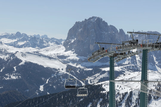 View of snowy mountains and ski lifts in the Dolomites, Italy. This scene captures winter sports activities at a popular ski resort.