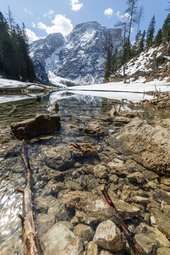 Lake Braies in the Dolomites, Italy, with snowy mountains and clear water reflecting the landscape in winter.